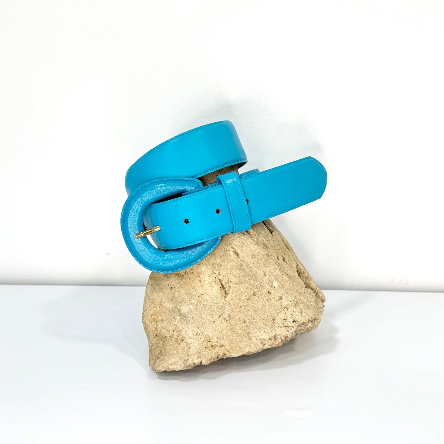 Vintage Fob Trading turquoise blue leather belt styled on stone